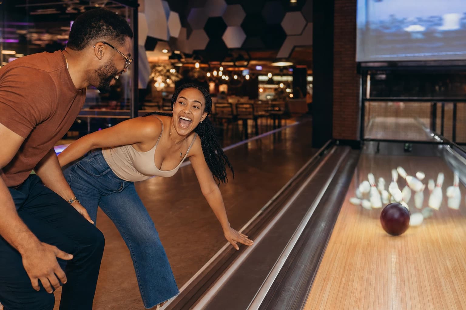 Playful couple on a fun bowling date night